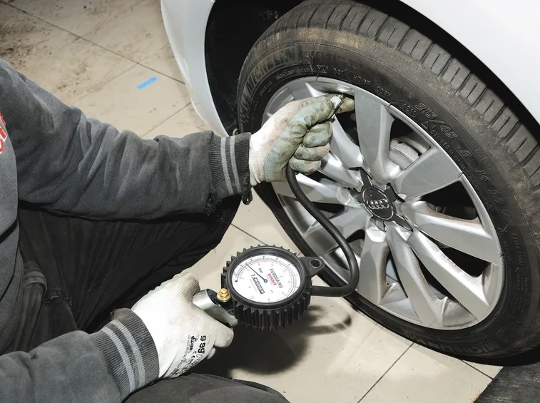 Gommista che controlla la pressione delle gomme
